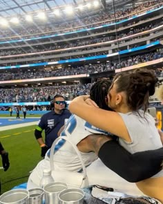 two women hugging each other at a sporting event