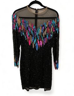 This is a stunning vintage 80s sequin and beaded cocktail dress. It is a size 4 and knee length, with a zipper closure. There is also a build in padded bra. This dress is extremely rare and in amazing condition! Such a statement dress that would look fabulous at a cocktail party, wedding or a night out. Beaded Sequin Dress For Prom Party, Vintage Style Embellished Evening Dress For Party, Beaded Sequin Dress For Evening In Spring, Vintage Mini Dress For Party Season Night Out, Vintage Mini Dress For Night Out During Party Season, Vintage Sequin Dress For Evening, Vintage Beaded Dresses For Night Out, Beaded Sequin Dress For Cocktail Parties, Beaded Sequin Dress For Party Season Night Out