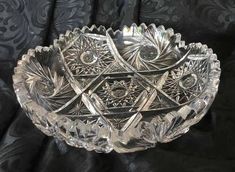 a clear glass bowl with an intricate design on the bottom and sides, sitting on a black background