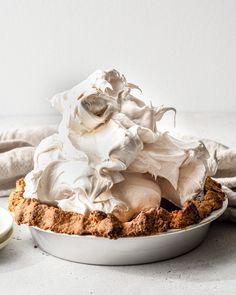 a pie topped with whipped cream in a white dish