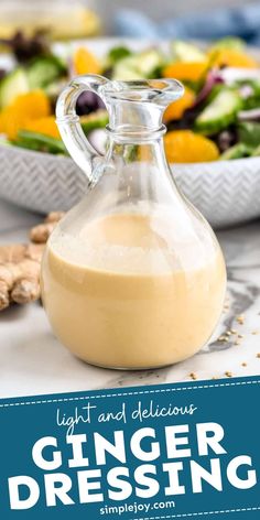 a glass bottle filled with ginger dressing next to a bowl of salad