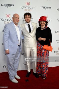 two men and a woman pose for the camera on the red carpet at kentucky derby