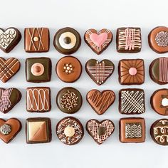 many different types of cookies and pastries on a white surface with the word love spelled in small letters