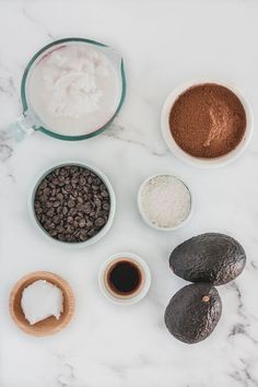 the ingredients to make an avocado smoothie laid out on a marble surface