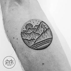 a man's arm with a mountain tattoo on it