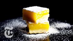 three pieces of yellow cake sitting on top of a table covered in powdered sugar