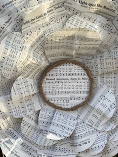 a wreath made out of sheet music paper with a ring on the middle surrounded by notes