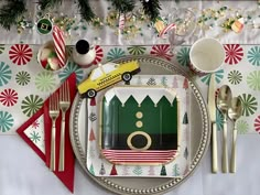 a christmas table setting with plates, silverware and napkins in the shape of cars