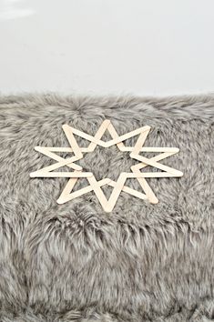 a wooden snowflake sitting on top of a furry surface