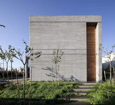 the house is made out of concrete and has steps leading up to it's entrance