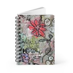 a spiral notebook with an abstract flower design on the front and back cover, featuring words written in cursive writing