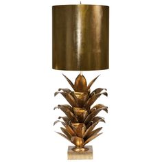 a golden pineapple lamp with a gold shade on the base and a black drum light behind it