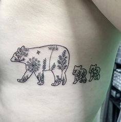 a bear and cub tattoo on the side of a woman's stomach, with trees