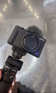 a person holding a camera with a microphone attached to it