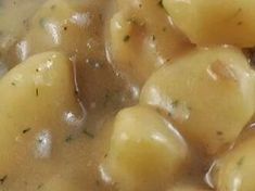 a close up view of some kind of food in a bowl with broccoli and gravy