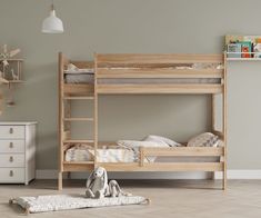 a wooden bunk bed sitting in a bedroom next to a white dresser and toy elephant