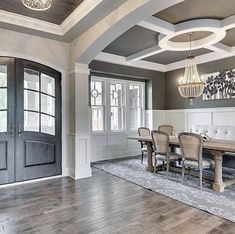 a large dining room with wooden floors and chandelier