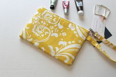 "This yellow and white damask pattern wristlet is perfect for the women who has a lot of style but is on the go! This wristlet is the perfect size for carrying all the necessities (cell phone, money, keys, makeup) and makes a great summer accessory. This wristlet is also the perfect size wallet. Colors: yellow, white Bag Measurements: 9.5 inches wide 6.5 inches tall Strap: 14\" long creating a 7\" loop ~ 100% cotton home decor fabric ~ 100% cotton lining ~ Two inside pockets ~ Lined with padded Yellow Wallet, Foldover Crossbody Bag, White Damask, Zippered Clutch, Belt Accessories, Boho Bag, Wristlet Wallet, Damask Pattern, Makeup Case