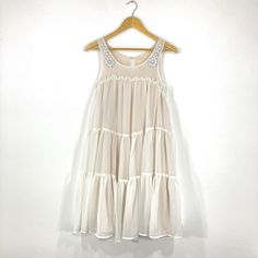 Beautiful trapeze dress by H&M in a Lightweight sheer cream fabric. The dress has a tiered trapeze design with white beading on the shoulders. In good condition. Measurements  Bust: 32" Length: 36" Flowy Embellished Summer Dresses, Summer Embellished Flowy Dresses, White Chiffon Dress With Ruffles For Beach, White Tiered Party Dress, Summer Chiffon Dress Embellished, White Flowy Tiered Dress For Summer, White Tiered Layered Dress, White Summer Tiered Dress For Party, White Layered Dresses For Spring