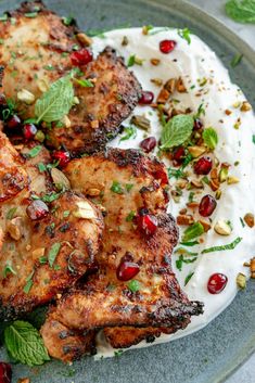 some chicken is on a plate with whipped cream and garnished with mint leaves