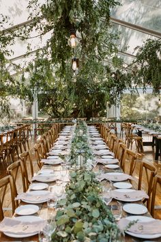 a long table is set up with plates and place settings for an outdoor wedding reception