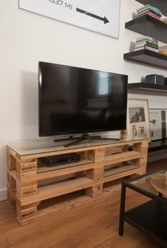 a flat screen tv sitting on top of a wooden entertainment center in a living room