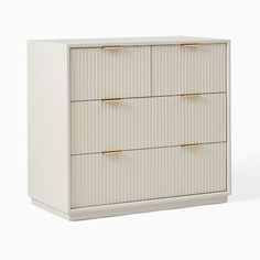 a white dresser with three drawers and gold handles on the bottom, against a white background