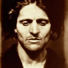 an old photo of a man with long hair