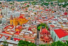 an aerial view of a city with lots of tall buildings and colorfully colored roofs