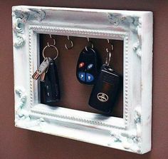 a white frame with two keys hanging on it