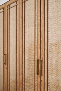 a wooden room divider with woven coverings on it's sides and doors