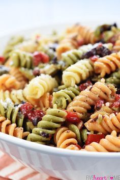 a white bowl filled with pasta salad on top of a table