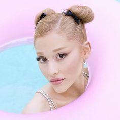 a woman in a pink pool with her hair pulled back into a pony tail style bun