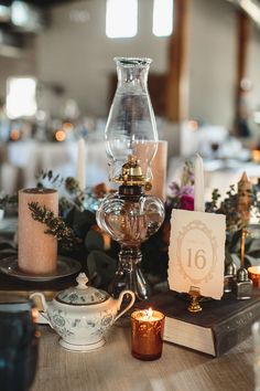 the table is set with candles, teacups and other things to be used as centerpieces