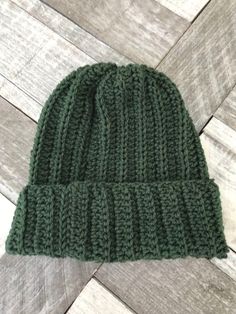 a green knitted hat sitting on top of a wooden floor