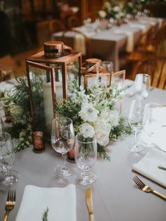 the table is set with white flowers and candles