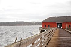 a red building sitting on top of a wooden pier