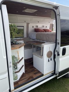 the interior of a camper van with its door open and bed in the back