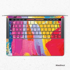 an image of a laptop with colorful paint on it's keyboard and mouse pad