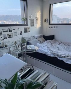 a bed sitting in a bedroom next to a window with lots of pictures on the wall