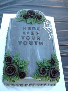 a tombstone with roses on it that says here lies your youth in frosting and spider webs