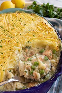 a casserole dish with peas and lemon is shown in the foreground text reads easy british fish pie with peas and lemon