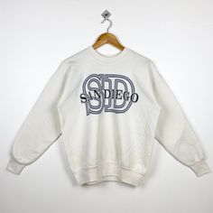 90s San Diego Crewneck Sweatshirt Print Logo White Color Men's M - Made in Usa - Materials : Cotton, Polyester  - Tag Reads : M Kindly see the actual measurements (All measurements were taken lying flat) - Actual size manual measurements * Width (Armpit to armpit) : 22 inches * Length (Shoulder to end of garment) : 24 inches * Sleeve length : 21 inches - Condition : * Vintage condition 9/10 (90%) * Free from hole and major defect - Shipping : * DHL EXPRESS = 3-6 business day arrived * Please PROVIDE your PHONE/CONTACT NUMBER for SHIPPING/DELIVERY purpose DON'T FORGET TO VISIT MY SHOP FOR MORE GREAT STUFF, THANK YOU. Vintage White Sweatshirt With Logo Print, 90s White Sweatshirt With Letter Print, White Crew Neck 90s Sweatshirt, White 90s Crew Sweatshirt, White 90s Crew Neck Sweatshirt, 90s White Crew Sweatshirt, American Vintage Clothing, Nike Crewneck Sweatshirt, Sweatshirt Print