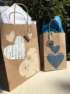 two paper bags with hearts on them are sitting on a table next to each other