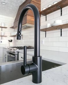 a black faucet sitting on top of a kitchen counter