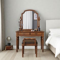 a bedroom scene with focus on the dressing table and mirror, along with a bed