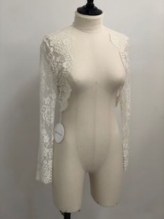 Our delicate French Chantilly lace shrug in ivory will beautifully finish any bridal look. Handmade with sheer French Chantilly lace, our Catherine sheer bolero adds coverage without concealing the details of your gown. Long fitted sleeves complete the look. Wear this delicate piece to add a layer of illusion coverage to a strapless gown. Available in Ivory and Black. White Lace Bolero, Long Sleeve Lace Shrug For Wedding, Fitted Lace Shrug With Lace Trim, Lace Long Sleeve Wedding Shrug, Lace Bolero Wedding Long Sleeve, Tulle Bolero, Rework Clothes, French Chantilly Lace, Lace Shrug