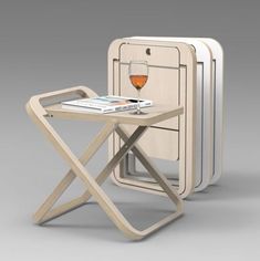 a small table with a glass of wine on it next to three folding trays