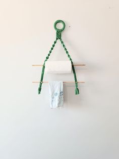 two towels are hanging on the wall next to some clothes pins and a green rope