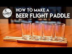 four shot glasses sitting on top of a wooden tray with the words how to make a beer flight paddle